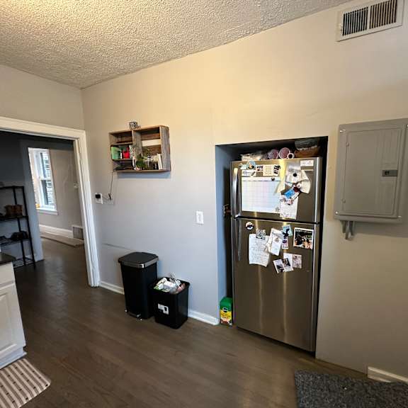 a kitchen with a fridge full of magnets and notes.