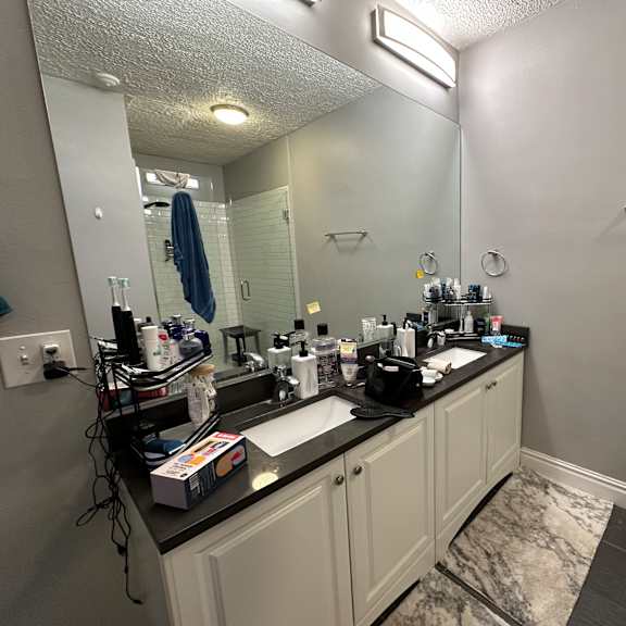 a bathroom with a sink, mirror, and a towel hanging on the wall.