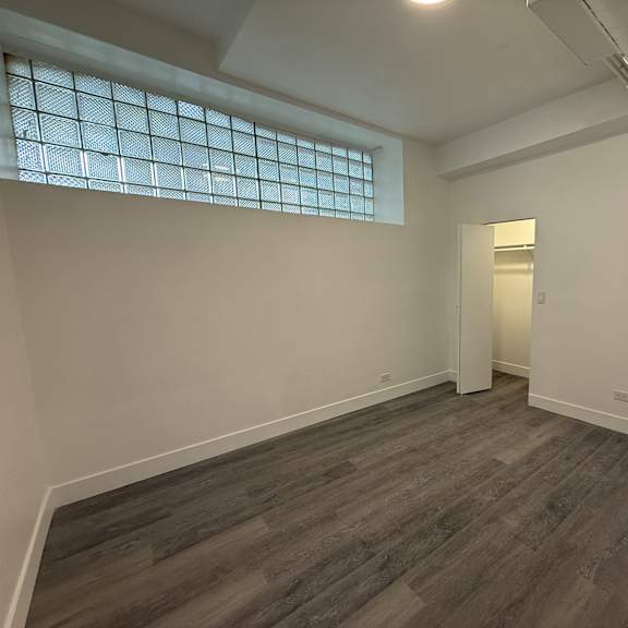 a room with a wooden floor and a window with a grid pattern.