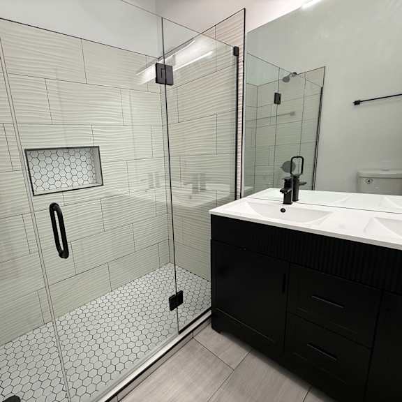 a bathroom with a walk-in shower and a sink.