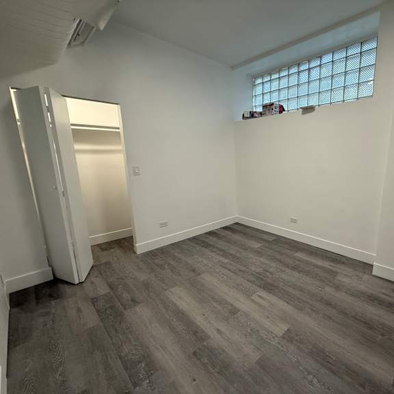 a room with a grey floor and a window with blinds.
