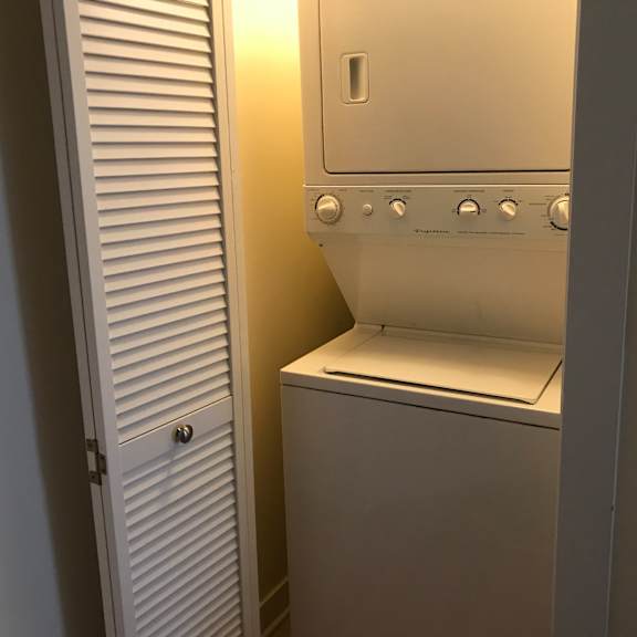 a white oven with a door open is in a room with a white door to the left.