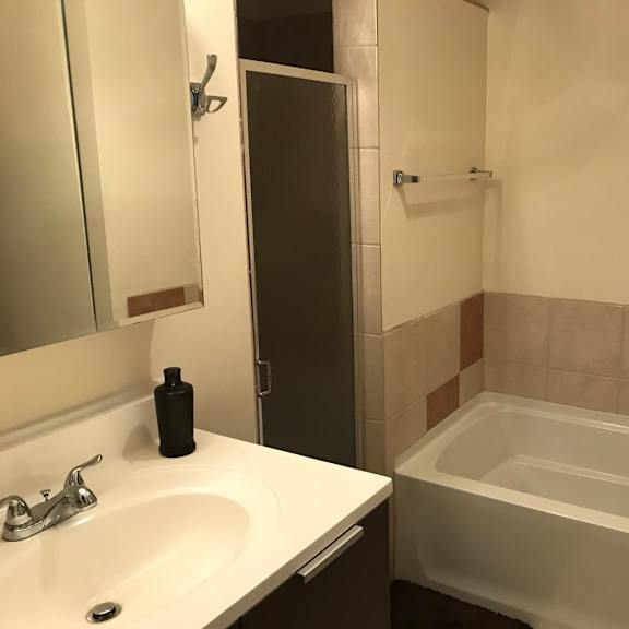 a white sink with a black bottle on it.