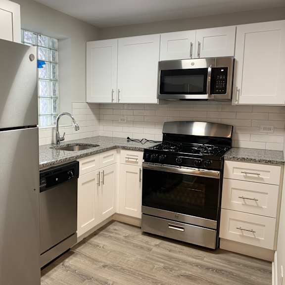 a kitchen with a stainless steel refrigerator, microwave, oven, and stove.