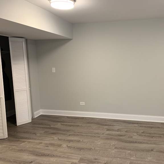 a room with a grey floor and a white ceiling with a light fixture.