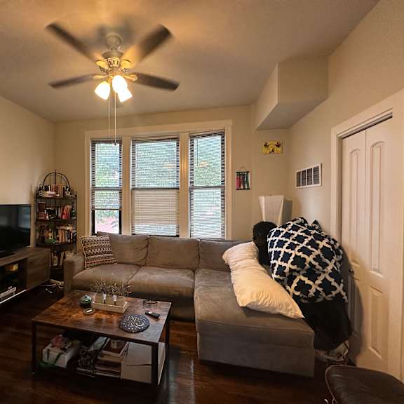 a living room with a grey couch and a television.
