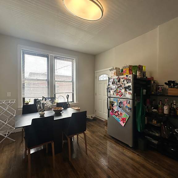 a kitchen with a table and chairs and a refrigerator with magnets on it.
