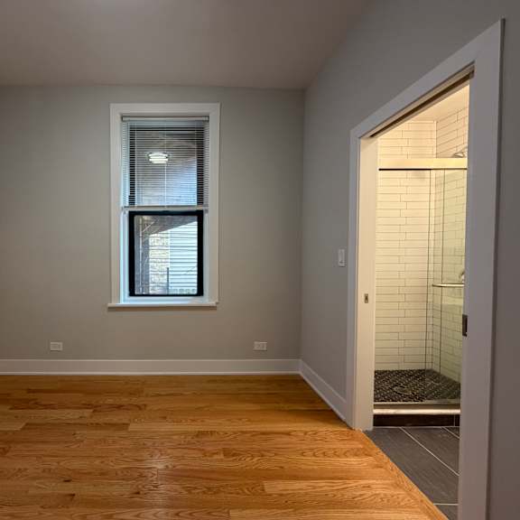a room with a window and wooden flooring.