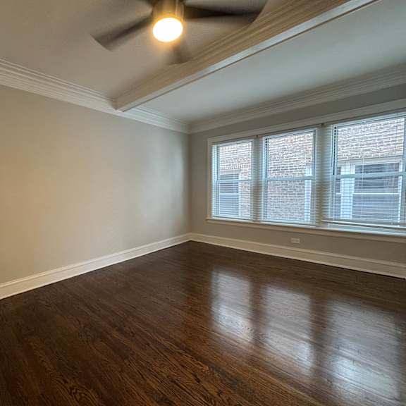 a room with wooden floors and a ceiling fan.