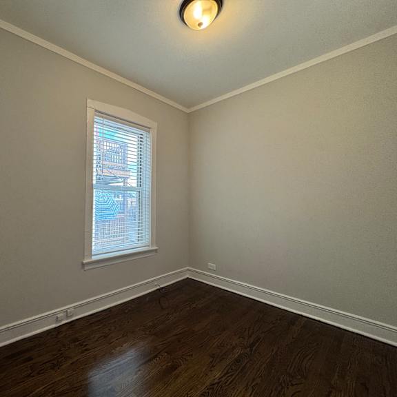 a room with a window and wooden flooring.