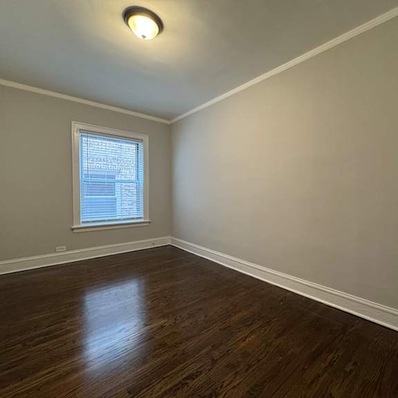 a room with a window and wooden floors.