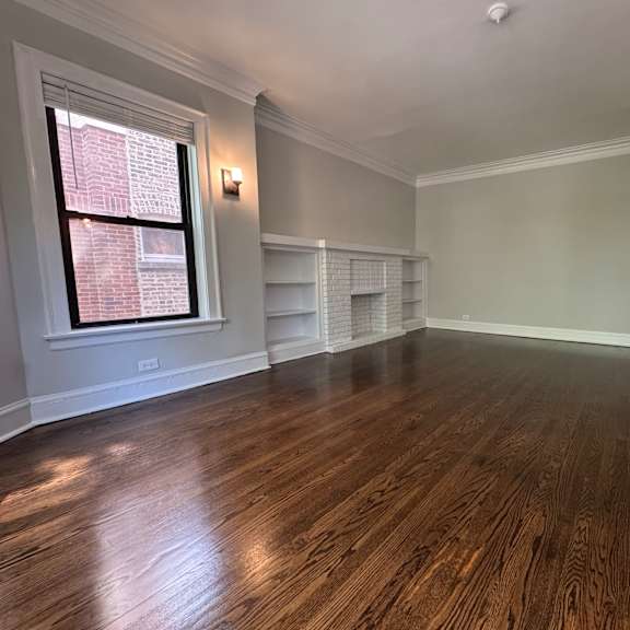a room with wooden floors and a window.