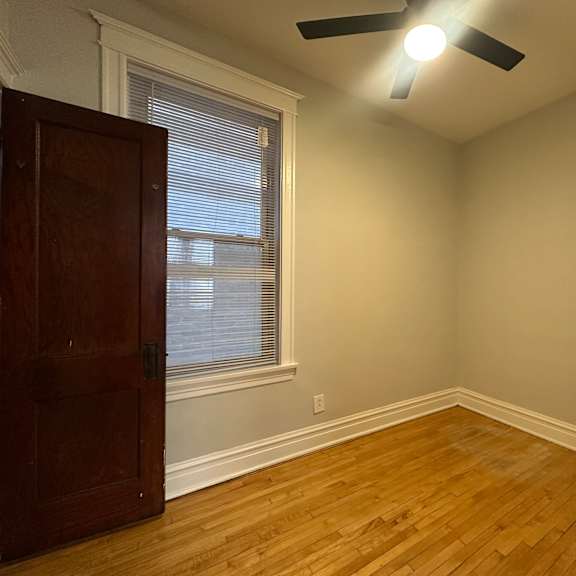 a room with a ceiling fan and a wooden floor.