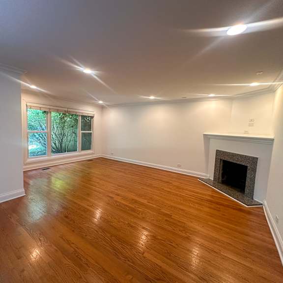 a room with a fireplace and wooden flooring.
