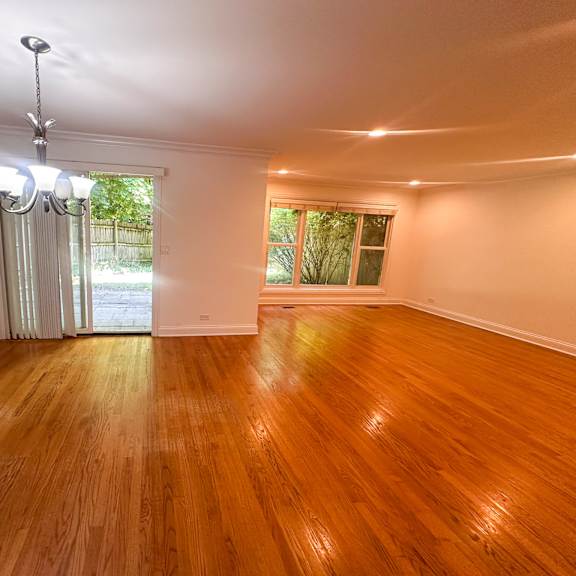 a room with wooden flooring and a chandelier.