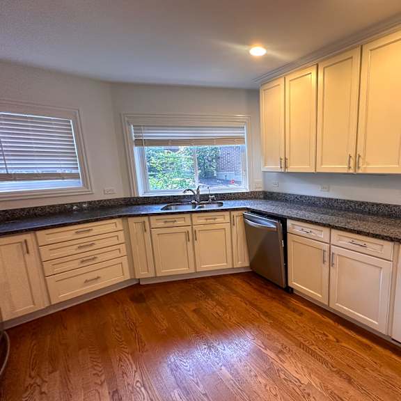 a kitchen with white cabinets and a black countertop.
