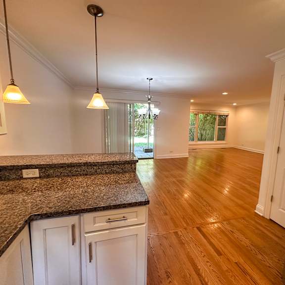 a kitchen with wooden floors and granite countertops.