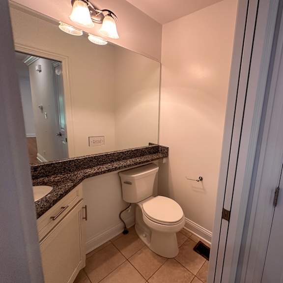 a white toilet sits in a bathroom next to a sink.