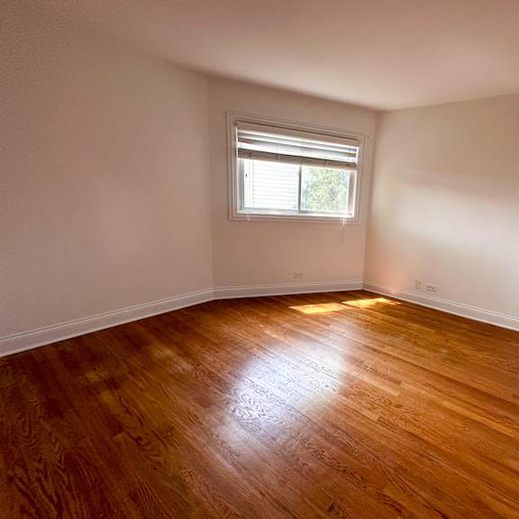 a room with wooden flooring and a window.