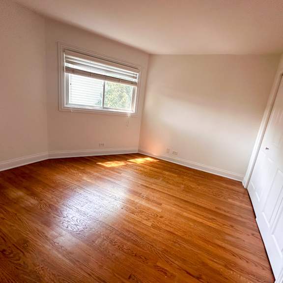 a room with wooden flooring and a window.