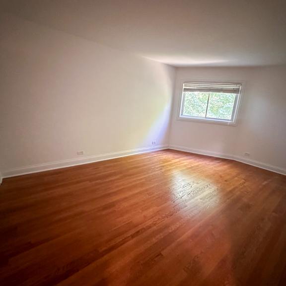 a room with wooden flooring and a window.