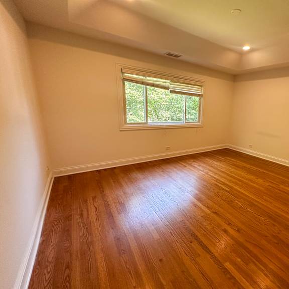 a room with wooden flooring and a window.
