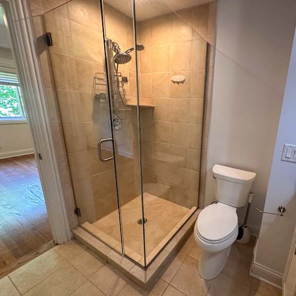 a bathroom with a toilet, sink, and walk-in shower.