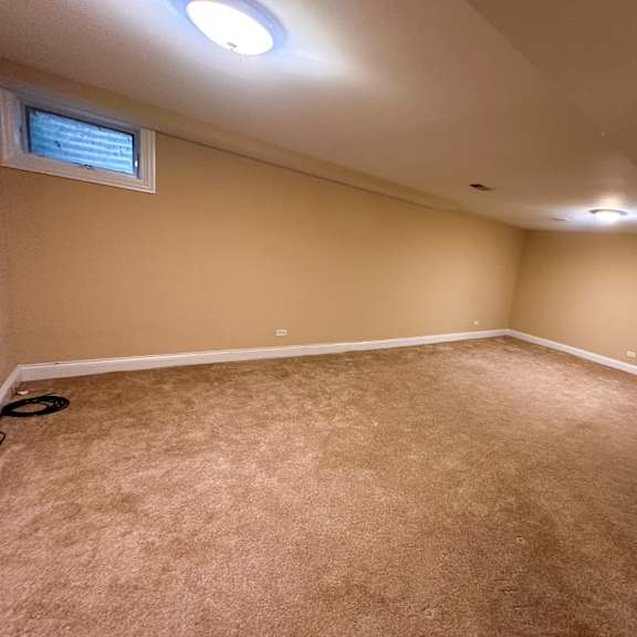 a room with a carpeted floor and a window on the wall.