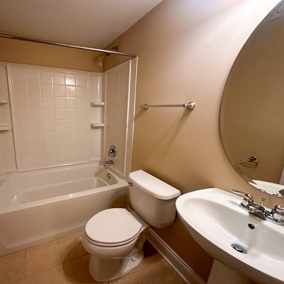 a bathroom with a toilet, sink, and bathtub.