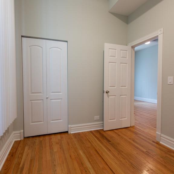 a room with a white door and a wooden floor.