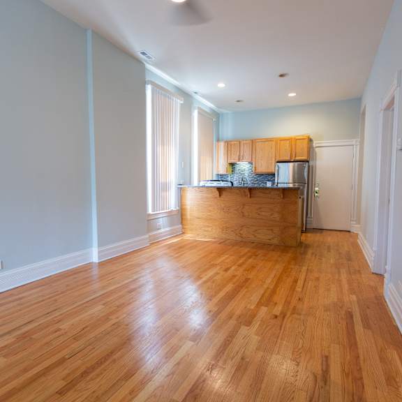 a kitchen with wooden floors and white walls.