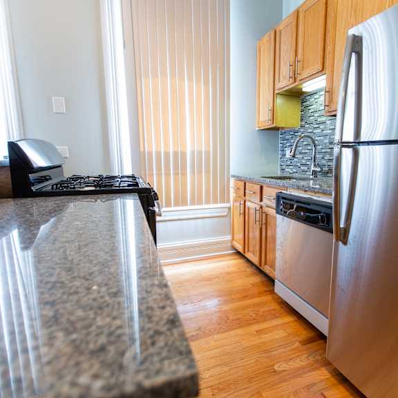 a kitchen with a granite counter top and a stainless steel refrigerator.
