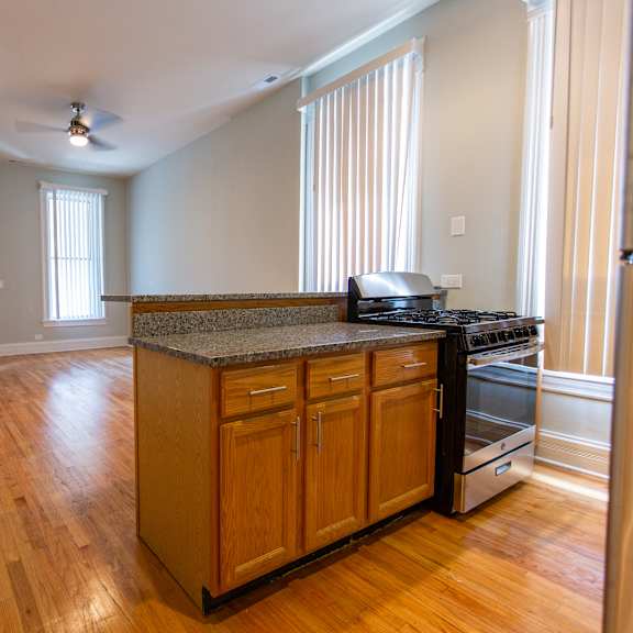 a kitchen with wooden cabinets and a stove top oven.