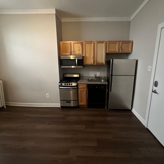 a kitchen with a refrigerator, oven, and microwave.