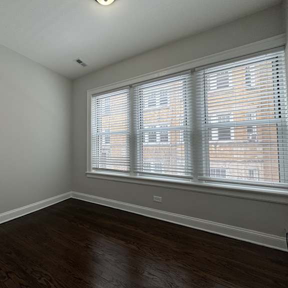 a room with a window and wooden floors.