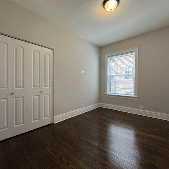a room with a white door and a window with blinds.