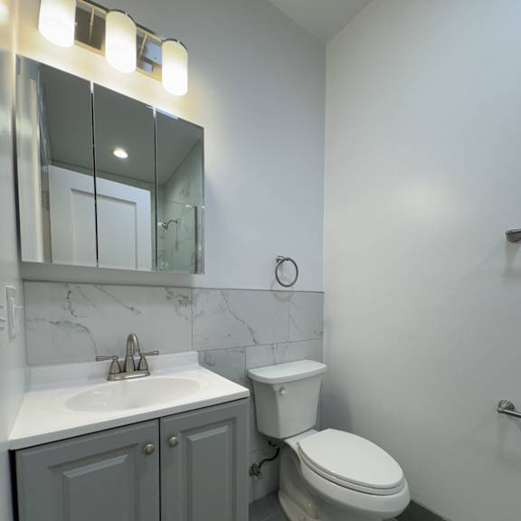 a white toilet sits next to a sink in a bathroom.