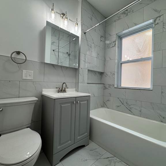 a white toilet sits next to a sink in a bathroom.