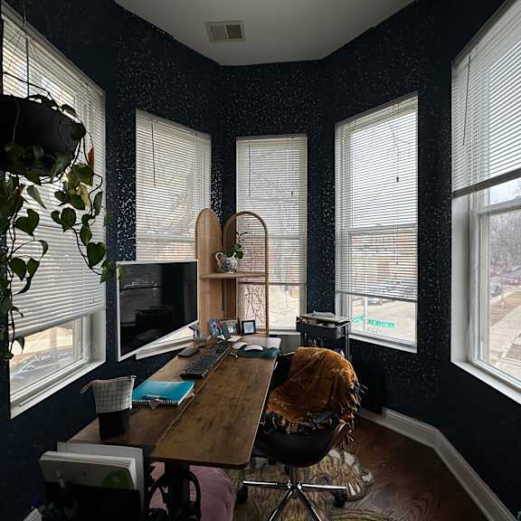 a room with a desk, chair, and a computer monitor.
