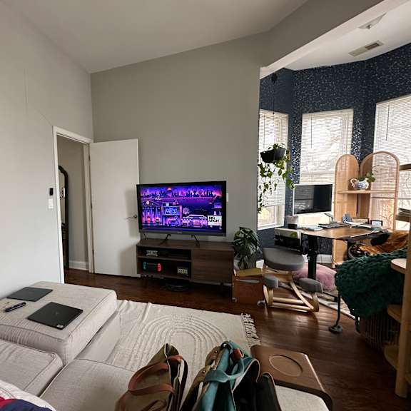 a living room with a grey couch and a television on a wooden stand.