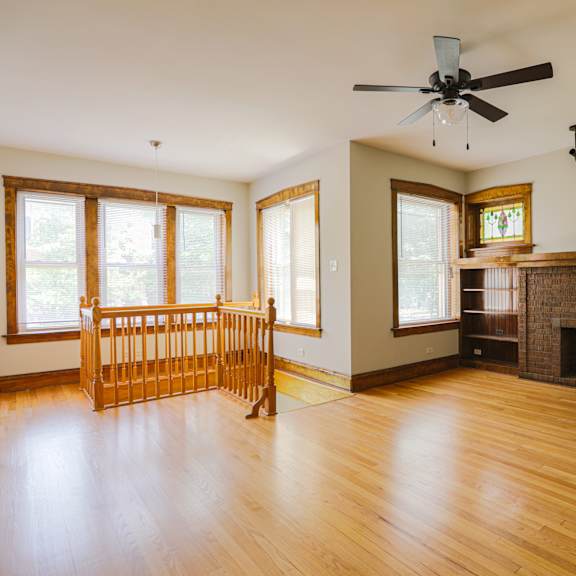 a living room with a fireplace and a fan.