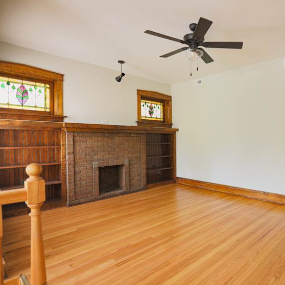 a room with a fireplace and wood floors.