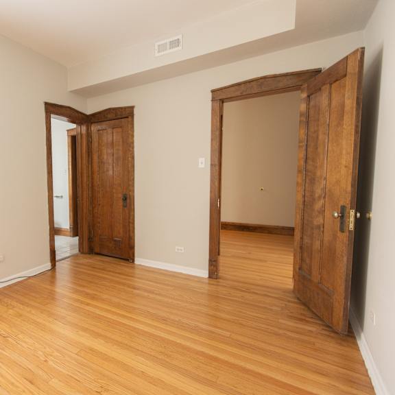 a room with wooden floors and a window on the left side.
