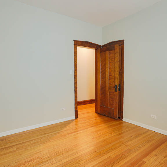 a room with a wooden floor and a wooden door.