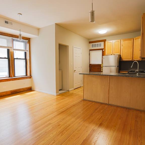 a kitchen with wooden floors and a window.