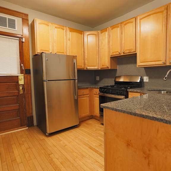 a kitchen with wooden cabinets and a granite counter.