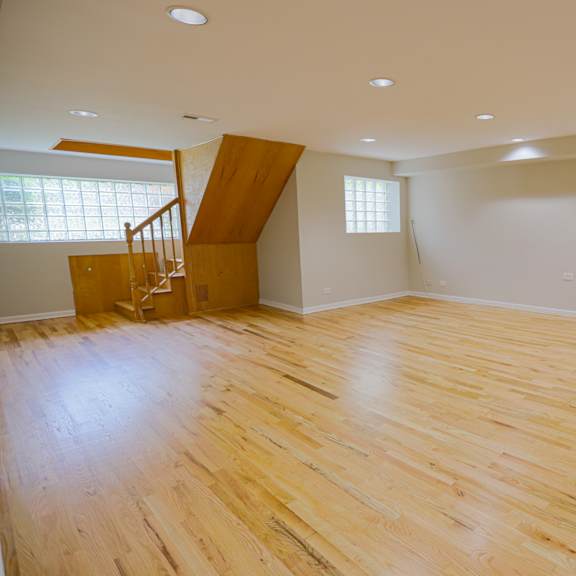 a room with wooden flooring and a staircase.
