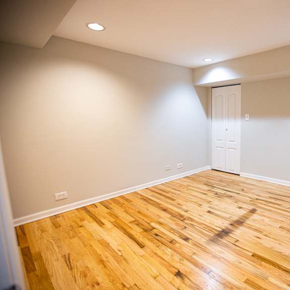 a room with wooden flooring and a white door.