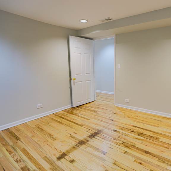 a room with wooden flooring and a white door.