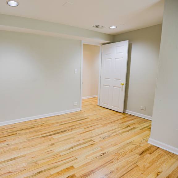 a room with a wooden floor and a white door.